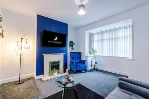 a living room with a blue accent wall at Charming 2 Bed House, Sleeps 6, Free parking, Contractors welcome in Elland