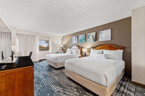 a hotel room with two beds and a television at Delta Hotels by Marriott Mount Pleasant in Racine