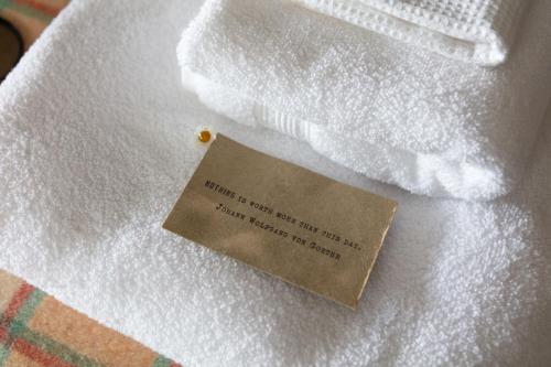 a piece of paper sitting on top of a white blanket at Nest Stay By The Butler Collection in Pulborough