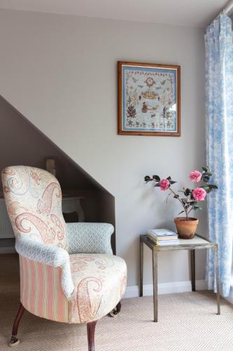 a living room with a chair and a table at Nest Stay By The Butler Collection in Pulborough
