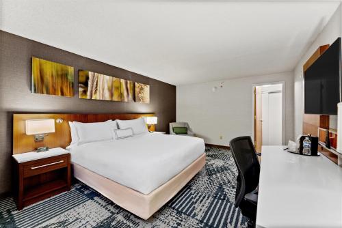 a hotel room with a large bed and a desk at Delta Hotels by Marriott Mount Pleasant in Racine