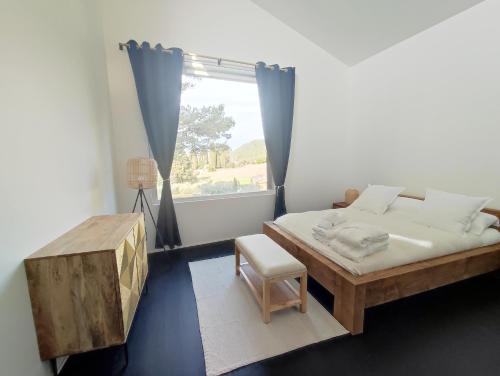 une chambre avec un lit, une table et une fenêtre dans l'établissement La Maison joyeuse à 5 minutes d'Uzès, à Montaren-et-Saint-Médiers