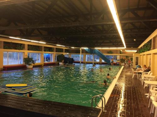 a large swimming pool with people in the water at Appartement Zeeland, Clipper 25 in Bruinisse