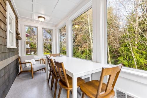 comedor con mesa blanca, sillas y ventanas en Wayfinder by Seabrook Hospitality, en Pacific Beach
