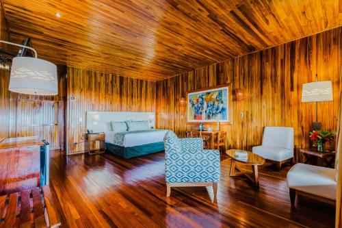 a living room with a bed and a couch and chairs at Hotel Heliconia - Monteverde in Monteverde Costa Rica