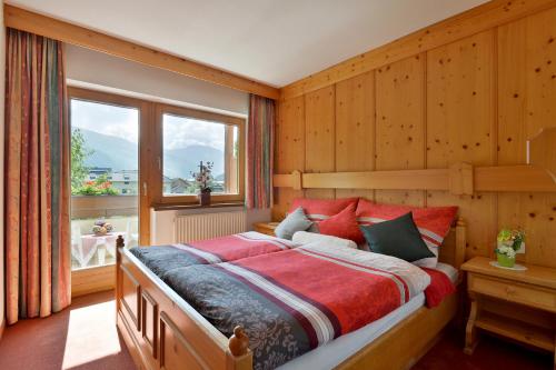 a bedroom with a large bed and a window at Appartementhaus Kaltenbach-Stumm by PiaundDirk in Stumm