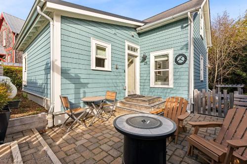 Casa azul con patio con mesa y sillas en Wayfinder by Seabrook Hospitality, en Pacific Beach