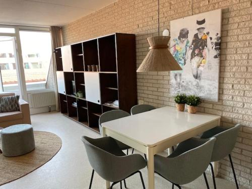 a dining room with a white table and chairs at Appartement Zeeland, Clipper 25 in Bruinisse