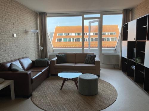 a living room with a couch and a table at Appartement Zeeland, Clipper 25 in Bruinisse