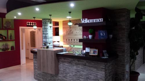 a restaurant with a counter in the middle of a room at Hotel Villa Nadin in Mostar
