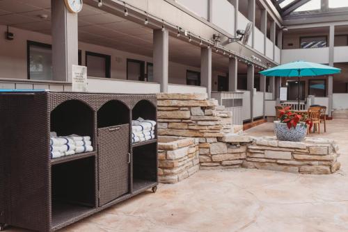 a building with a stone wall and an umbrella at Americinn by Wyndham Appleton Downtown in Appleton