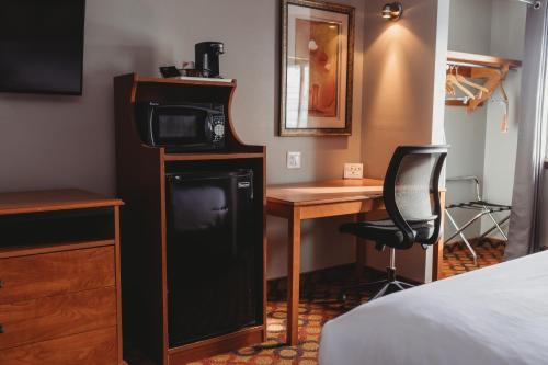 a room with a microwave and a desk and a bed at Americinn by Wyndham Appleton Downtown in Appleton