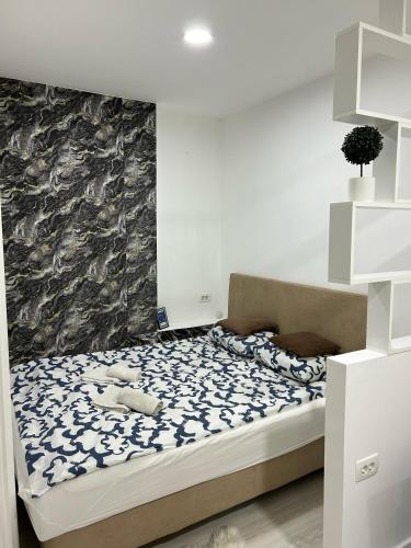 ein Schlafzimmer mit einem Bett mit einer schwarzen und weißen Decke in der Unterkunft M-Home Mostar in Mostar