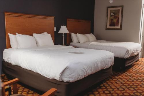 a hotel room with two beds with white sheets at Americinn by Wyndham Appleton Downtown in Appleton