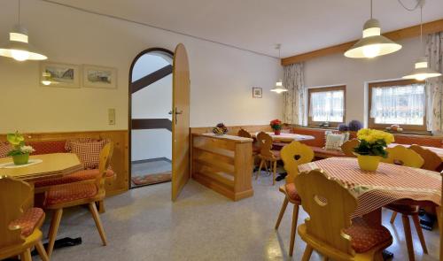 a dining room with tables and chairs and an open door at Appartementhaus Kaltenbach-Stumm by PiaundDirk in Stumm
