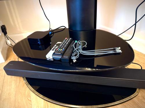 a black table with a remote control on it at New Forest Cozy 3-Bed Family Cottage, PaultonsPark in Bartley