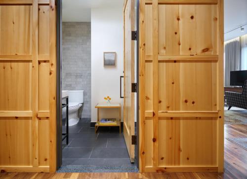 a bathroom with wooden doors and a toilet at Limelight Hotel Denver in Denver