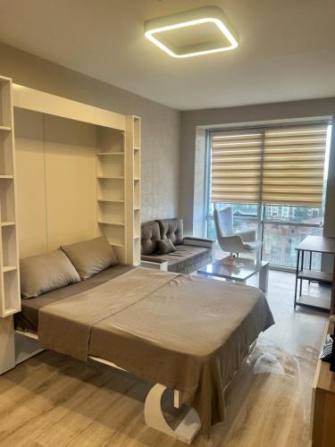 a bedroom with a large bed and a couch at Cozy Studio in Esenyurt