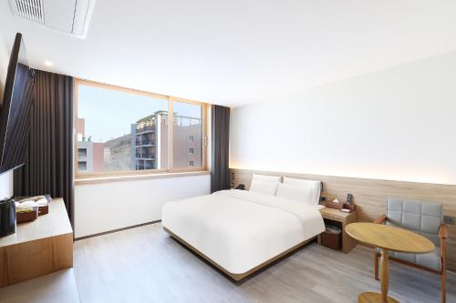 una camera da letto con un letto bianco e una grande finestra di Browndot Paju Heiri a Paju
