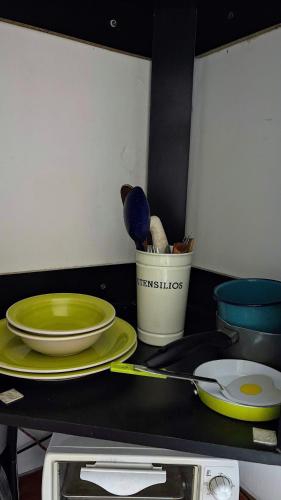 a kitchen counter with plates and utensils on it at Hostal Colonial Independiente in Mixco