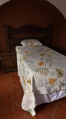 a bedroom with a bed with a wooden headboard at Hostal Colonial Independiente in Mixco