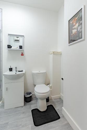 a white bathroom with a toilet and a sink at STAY HUB City Centre - Self Check-in in Birmingham