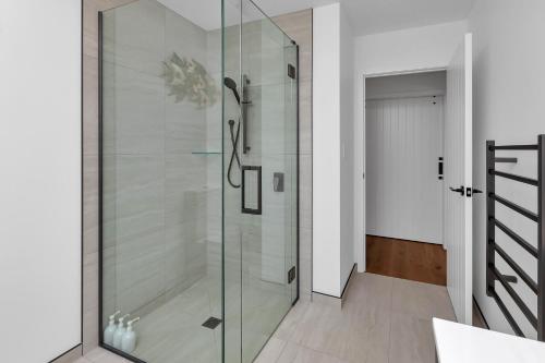 a shower in a bathroom with a glass door at Central Couples Retreat - Mangawhai Heads Unit in Mangawhai