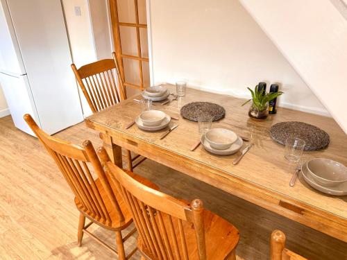 a wooden table with plates and dishes on it at New Forest Cozy 3-Bed Family Cottage, PaultonsPark in Bartley