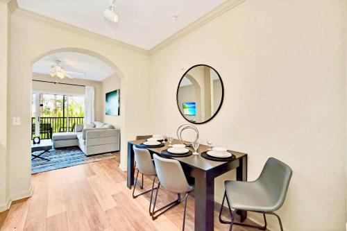 a dining room with a table and chairs and a mirror at Near Disney - Spacious 3BR Condo with Pool in Orlando