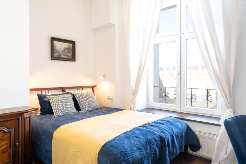 une chambre avec un lit et une grande fenêtre dans l'établissement MYE Apartments - Retro Piotrkowska, à Łódź