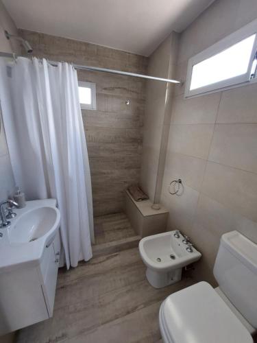 a white bathroom with a sink and a toilet at Sol de la Perla in Mar del Plata
