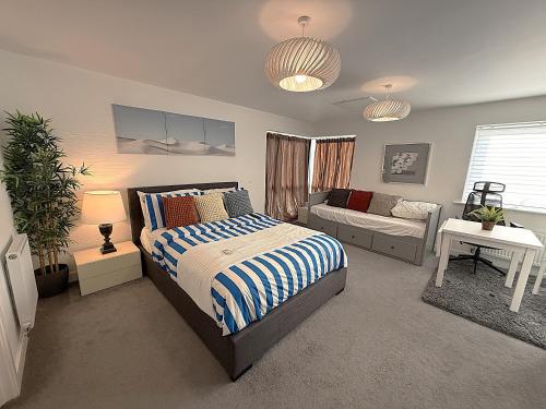 a bedroom with a bed and a couch at Luxury Rooms - Pick a Room - Free Parking & Kitchen Access, Near Etihad Stadium, The Coop Live & Piccadilly Station, Manchester in Manchester