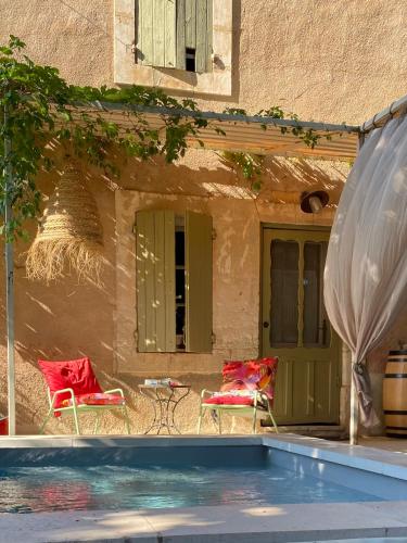 un patio avec deux chaises et une piscine dans l'établissement L'Escarpolette, à Saint-Saturnin-lès-Apt