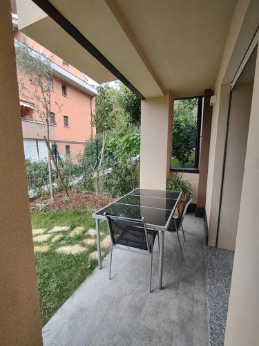 a glass table and chairs on a patio at L'incanto sui colli con giardino privato in Pianoro