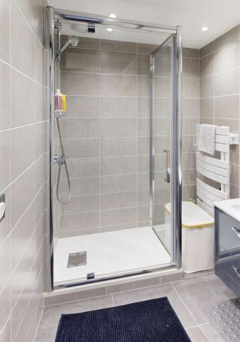 une douche avec une porte vitrée dans une salle de bain dans l'établissement La perle de Bussy- Grand studio cosy -Parking-Balcon- Disneyland - Paris, à Bussy-Saint-Georges
