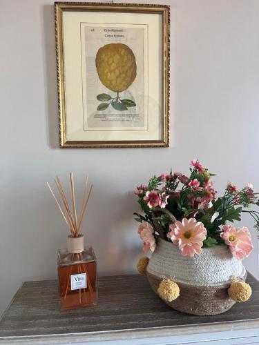 two vases on a table with flowers and a picture at CharmandView Assisi in Assisi