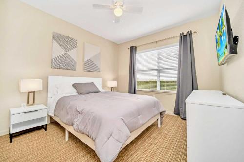a bedroom with a large bed and a window at Spacious 3BR Condo with Pool and Hot Tub, near Disney! in Orlando