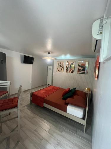 a bedroom with a bed with a red comforter at Charmant Studio Cosy Amatera in Fort-de-France