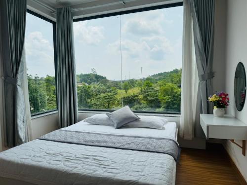 ein Schlafzimmer mit einem Bett und einem großen Fenster in der Unterkunft Hue Panorama Villa in Cư Chinh