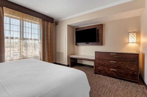 a hotel room with a bed and a flat screen tv at Best Western Premier Bridgewood Hotel Resort in Neenah