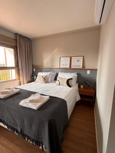 a bedroom with a large bed and a window at Flat Premiun Vila Madalena in São Paulo