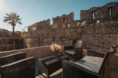 a balcony with chairs and a table and a wall at Villa il Borgο in Rhodes Town