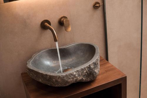 a bathroom with a stone sink with a faucet at Villa il Borgο in Rhodes Town