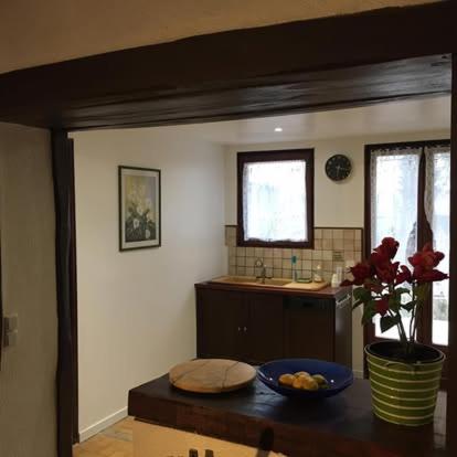 une cuisine avec une table avec un bol de fruits dessus dans l'établissement maison chaleureuse, à Épiais