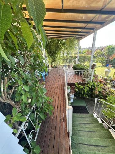 a wooden walkway with benches and plants in a garden at sweet house in Auckland