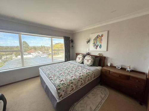 a bedroom with a bed and a large window at sweet house in Auckland