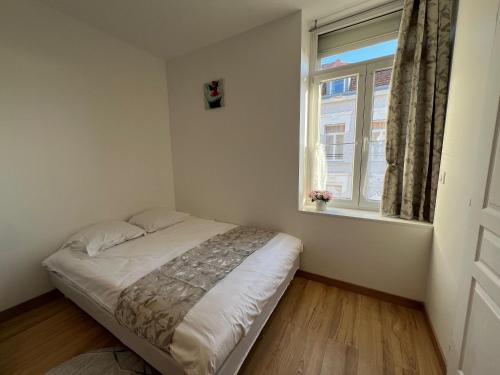 a small bedroom with a bed and a window at TherezAss Holiday in Calais