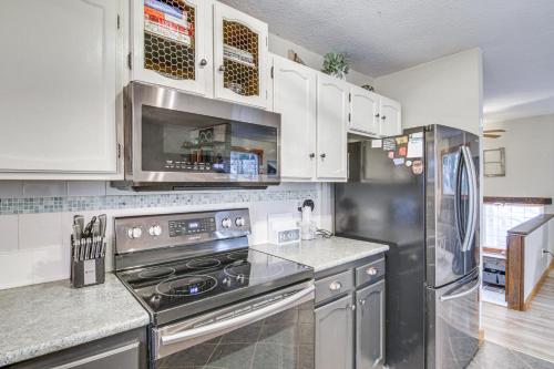 a kitchen with stainless steel appliances and white cabinets at 11 Mi to Bozeman Family Home with Movie Room! in Belgrade