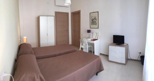 1 dormitorio con 1 cama y escritorio con TV en B&B Sorgente 23, en Salerno