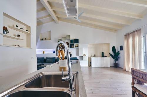 a kitchen with a sink and a living room at Beach Villa - By Bobbywashere in Santa Maria